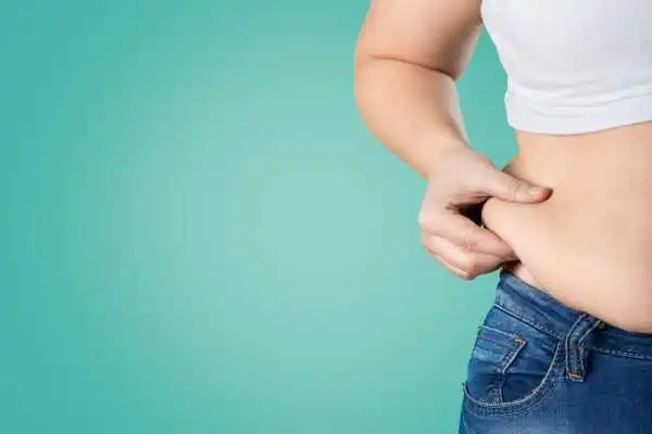 Image of woman pinching her love handles to show weight gain Barrow